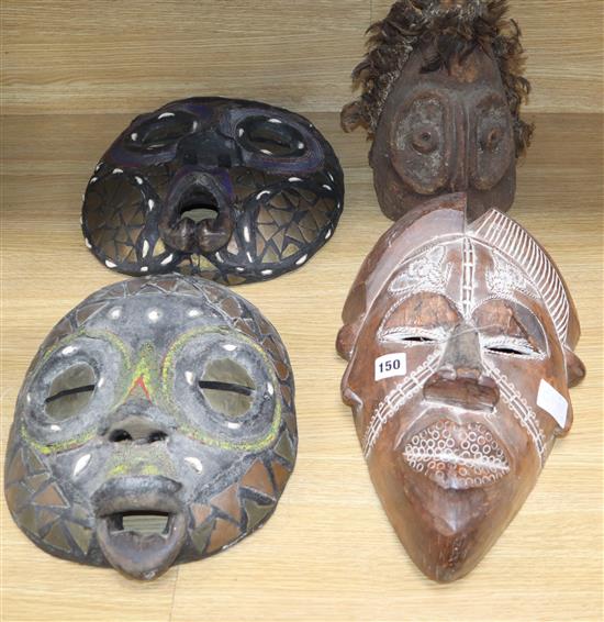 Two Luba bead worked tribal masks, another mask and a helmet mask